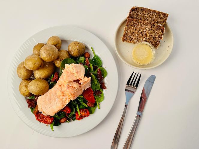 Um jantar feito com alimentos não processados ​​servido aos participantes do estudo: salada de quinoa e espinafre, batatas, salmão, pão de centeio, vinagrete de laranja, em 3 de março de 2022, na Faculdade de Medicina de Copenhague.