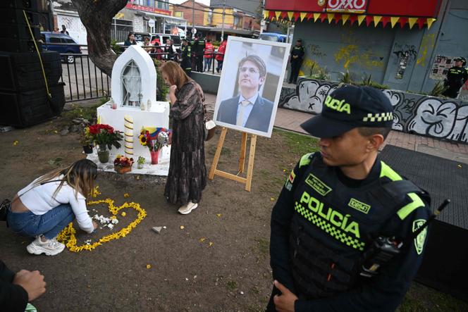 Une femme dépose des fleurs à côté d’un portrait du candidat colombien à la présidentielle assassiné, Miguel Uribe, dans le quartier de Modelia à Bogota, le 23 août 2025