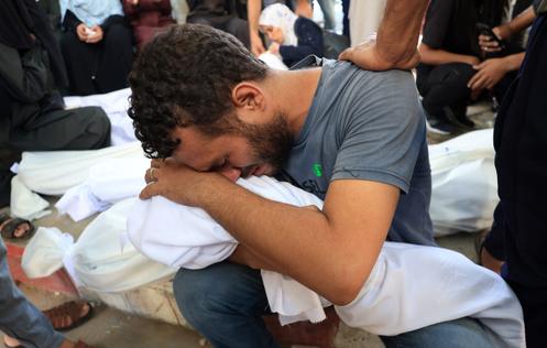 Un homme pleure le corps enveloppé d’un enfant, lors des funérailles de Palestiniens tués par une frappe israélienne nocturne sur une tente, à l’hôpital Al-Shifa de la ville de Gaza, le 29 août 2025.