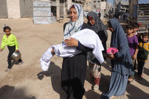 Une Palestinienne transporte le corps d’un enfant devant l’hôpital Al-Shifa, dans la ville de Gaza, le 29 août 2025.