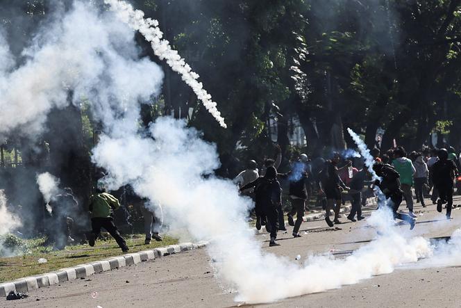 Des manifestants fuient les gaz lacrymogènes lors d’une manifestation antigouvernementale, à Djakarta (Indonésie), le 29 août 2025.