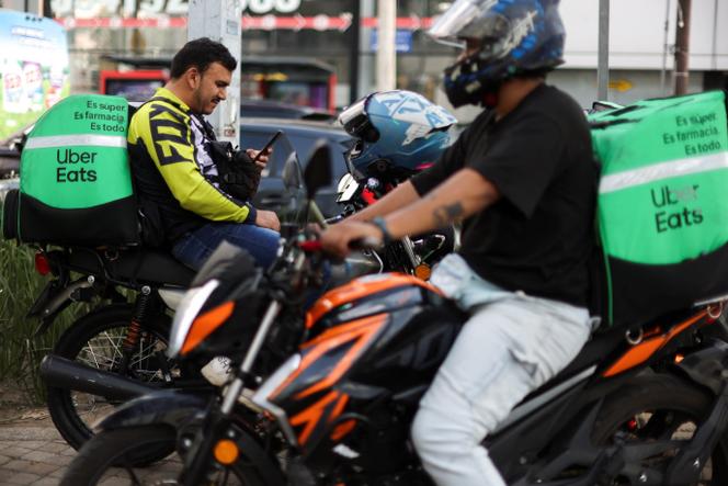Des livreurs d’Uber Eats se reposent en attendant des commandes à Mexico, le 16 octobre 2024.