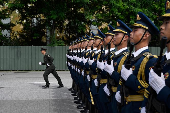 Un officier retourne à son poste après avoir corrigé des soldats de l’Armée populaire de libération chinoise alors qu’ils défilent lors d’une répétition pour le défilé militaire marquant le 80e anniversaire de la capitulation du Japon prévu le 3 septembre, dans une base militaire, à Pékin, le 20 août 2025.