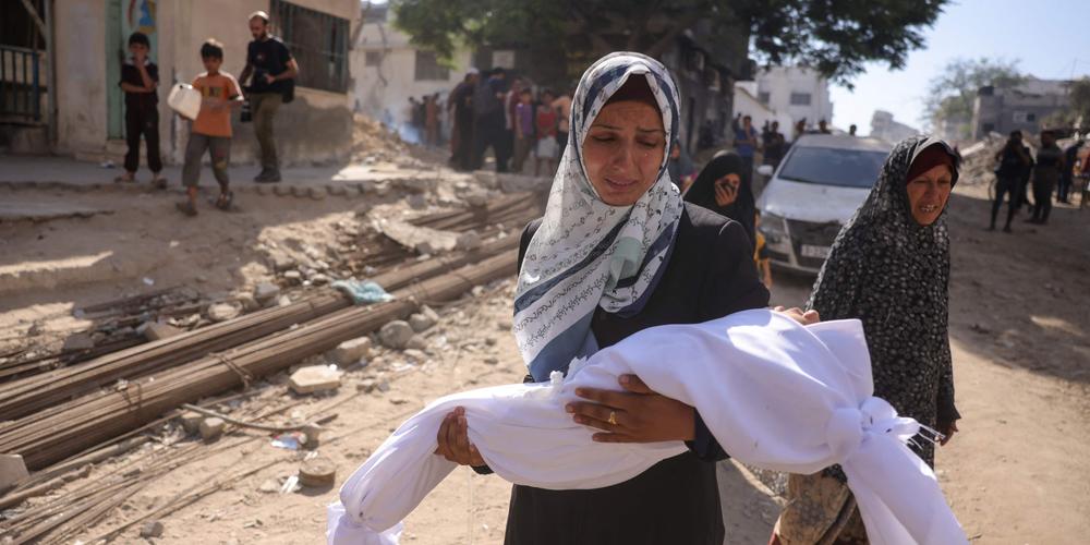امرأة فلسطينية تحمل جثة طفل أمام مستشفى الشفاء في غزة، 29 أغسطس 2025.