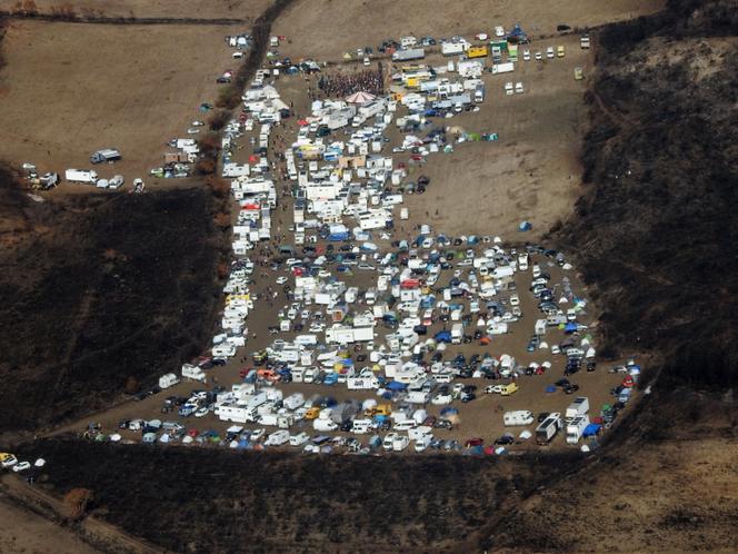 Une photo prise et publiée le 30 août 2025 montre une vue aérienne du site d’une rave-party organisée au milieu des terres brûlées à Fontjoncouse (Aude).