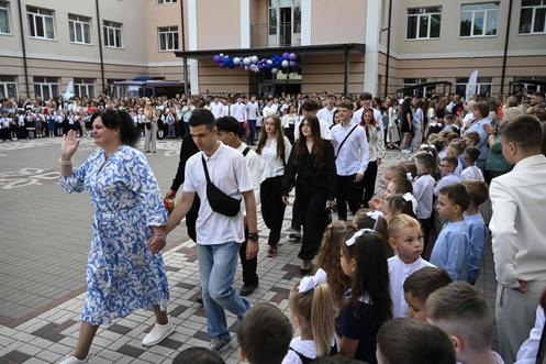 Une enseignante guide des élèves de première devant des élèves de CP, à l’occasion de la rentrée scolaire dans une école d’Irpine, près de Kiev, le 1er septembre 2025.