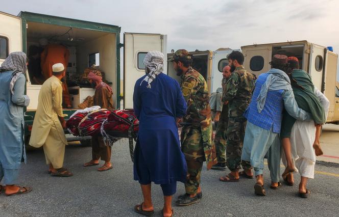 Taliban soldiers and civilians carry earthquake victims to an ambulance at an airport in Jalalabad, Afghanistan, on September 1, 2025.