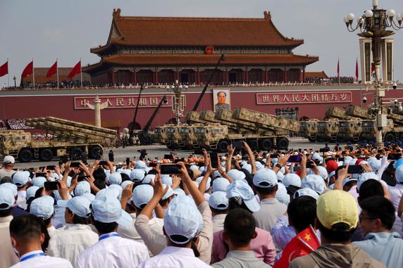 Des spectateurs observent le défilé militaire à Pékin, le 3 septembre 2025.