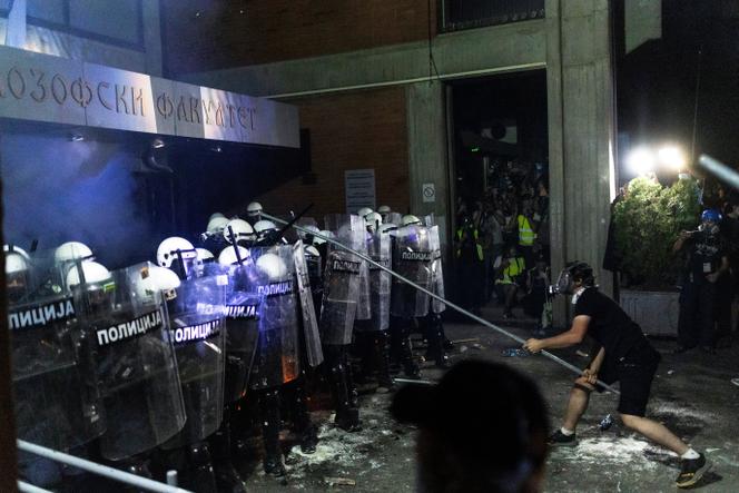 Un manifestant antigouvernement tend une perche en fer en direction de policiers antiémeute, à Novi Sad, en Serbie, le 5 septembre 2025.