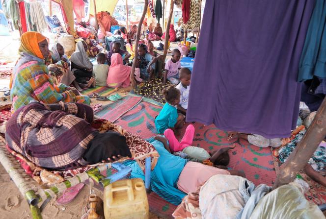 Des femmes et des enfants ayant fui les combats sont assis dans un camp de déplacés, à Al Dabbah, au Soudan, le 6 septembre 2025. 