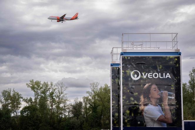 Un avion survole une unité mobile de traitement de la pollution de l’eau aux PFAS, fournie par Veolia, à son atterrissage à l’EuroAirport de Bartenheim, dans l’est de la France, le 4 septembre 2025.