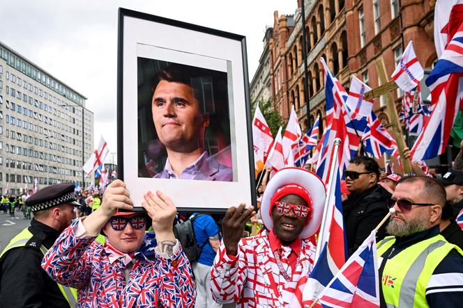 Lors du rassemblement  « Unite the Kingdom », des participants brandissent le portrait de l’activiste d’extrême droite américain Charlie Kirk, dans le centre de Londres, le 13 septembre 2025.