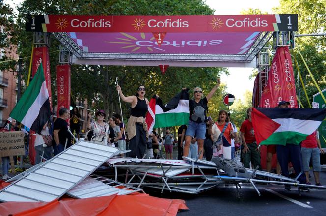 Des manifestants propalestiniens sous la flamme rouge du dernier kilomètre de la 21e étape de la Vuelta, le 14 septembre 2025 à Madrid.