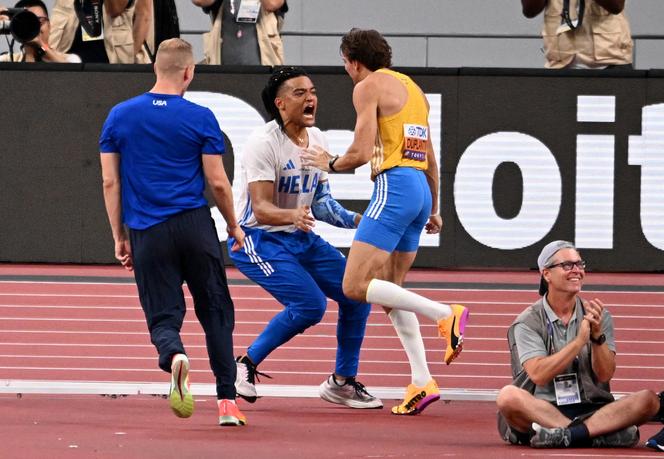Le Suédois Armand Duplantis, félicité par le Grec Emmanouil Karalis, après sa victoire aux championnats du monde d’athlétisme au concours de saut à la perche, à Tokyo, le 15 septembre 2025.