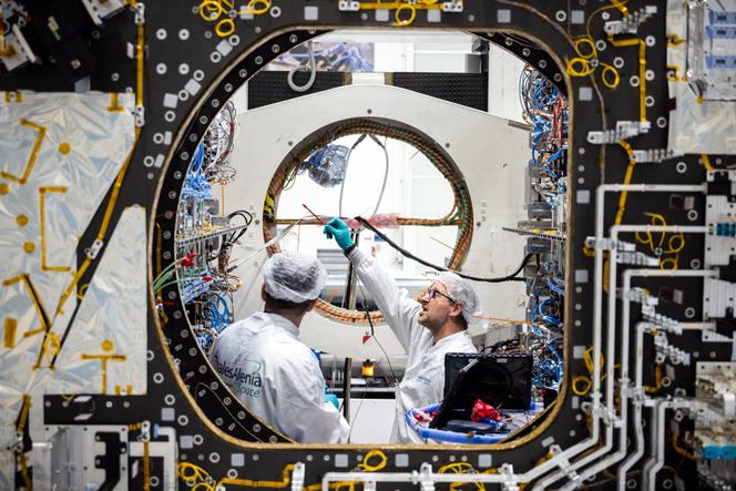 Des employés travaillent sur un satellite de communication dans une chambre blanche du constructeur aérospatial franco-italien Thales Alenia, à Toulouse, en mars 2023.