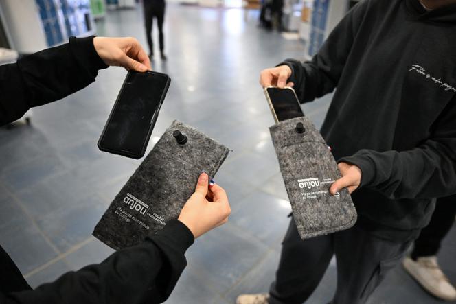 Des élèves du collège Anjou-Bretagne de Saint-Florent-le-Vieil (Maine-et-Loire) mettent leur téléphone portable dans une housse verrouillée jusqu’à la fin des cours, le 11 novembre 2024.