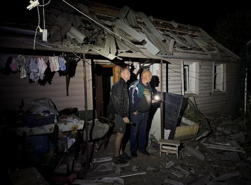 Des résidents se tiennent près d’un bâtiment endommagé lors d’une frappe de missile russe, à Zaporijia, en Ukraine, le 16 septembre 2025.