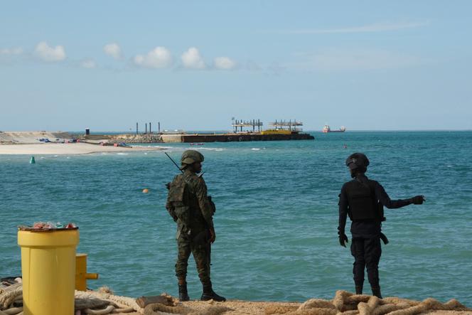 Un policier rwandais (à droite) et un soldat rwandais gardent le projet Total Mozambique LNG à Afungi, dans la province de Cabo Delgado, au Mozambique, le 29 septembre 2022. 