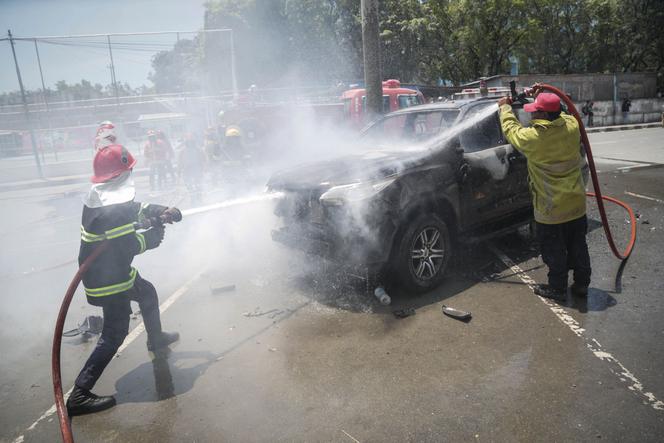 Des pompiers interviennent sur un véhicule gouvernemental incendié par des étudiants qui protestaient contre le projet du Parlement d’acheter 65 SUV pour les députés à Dili, au Timor oriental, le 16 septembre 2025.