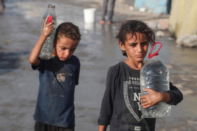Des enfants palestiniens transportent de l’eau malgré la pénurie, à Gaza, le 3 septembre 2025.