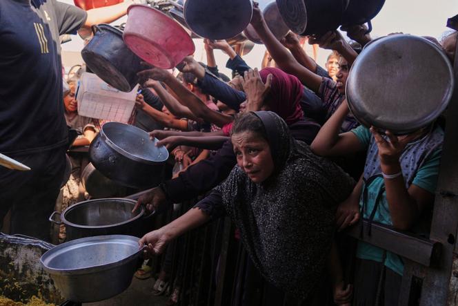 Des Palestiniens tentent d’obtenir de la nourriture distribuée dans une cuisine communautaire à Khan Younès, à Gaza, le vendredi 19 septembre 2025.