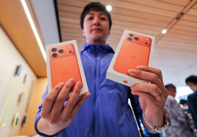 Un homme vient d’acheter deux iPhone 17 dans un magasin Apple, lors du lancement des ventes à Pékin, en Chine, le 19 septembre 2025.