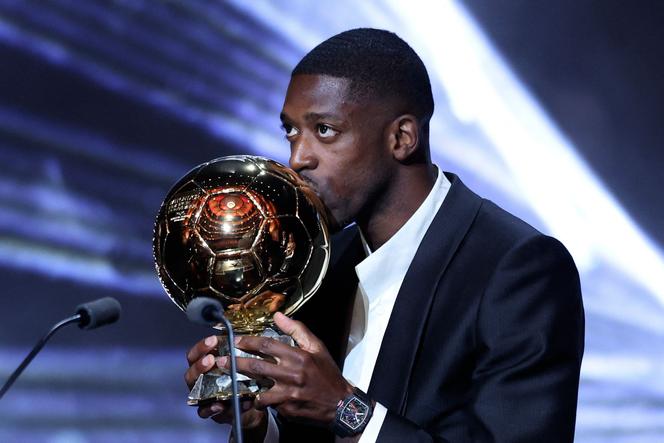 Paris Saint-Germain's French forward Ousmane Dembele kisses the Ballon d'Or award during the 2025 Ballon d'Or France Football award ceremony at the Theatre du Chatelet in Paris on September 22, 2025.