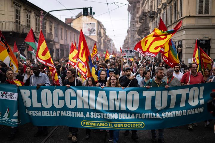 Des manifestants brandissent des drapeaux de l’Unione sindacale di base avec une banderole « Bloquons tout ! », lors d’une grève à Turin, le 22 septembre 2025.