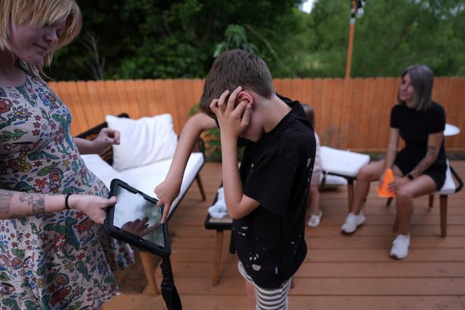 Un enfant, diagnostiqué autiste et non verbal, utilise un dispositif de communication améliorée et alternative pour communiquer avec un soignant, à Austin (Etats-Unis), le 12 mai 2025.