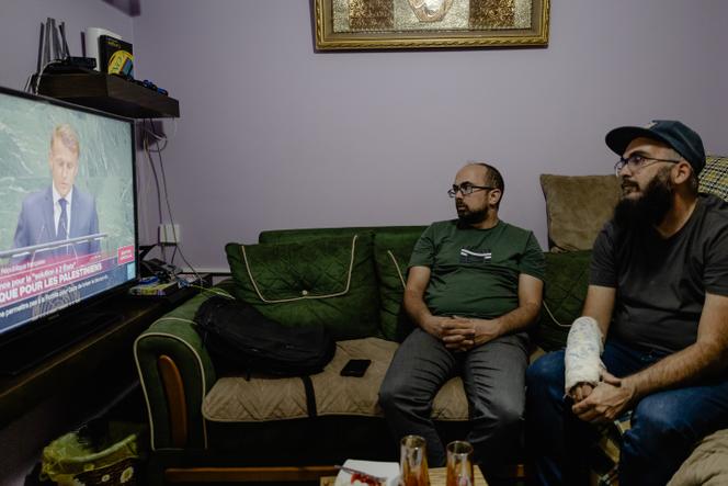 Fadi Abdel-Dayem, 47ans (à droite) et son frère Hischam (à gauche), regardent Emmanuel Macron à l'ONU, à Ramallah, le 22 septembre 2025. 