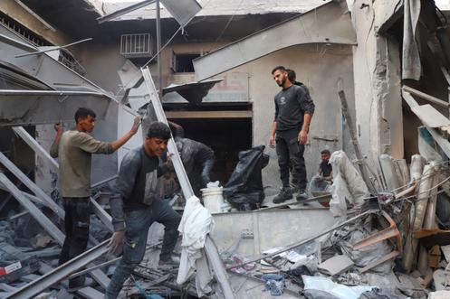 Des Palestiniens inspectent le site d’une attaque aérienne israélienne sur un immeuble abritant des déplacés, à Gaza, le 24 septembre 2025.