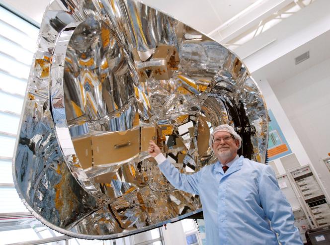 Le prix nobel 2006 de physique, l'Américain George Smoot, devant le miroir du satellite Planck, dans les ateliers d'Alcatel Alenia Space, à Cannes (Alpes-Maritimes, en février 2007.