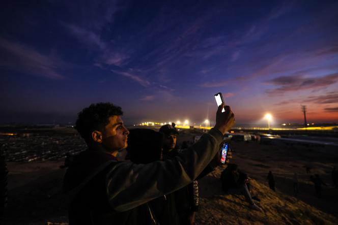 Des déplacés Palestiniens équipés de cartes eSIM tentent d’obtenir du signal pour contacter leurs proches sur une colline de Rafah, au sud de la bande de Gaza, à la frontière avec l’Egypte, le 19 janvier 2024.
