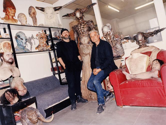Denis Gastou et Jean-Christophe Spadaccini, dans leur atelier, à Fontenay-sous-Bois, le 15 septembre, entourés de leurs créations. Sur le fauteuil, notamment, la jambe amputée de Sarah Bernhardt pour le film de Guillaume Nicloux (2024), la tête du comédien Melvil Poupaud utilisée dans « Petite Fleur », de Santiago Mitre (2022), le torse du Dracula de Luc Besson (2025).