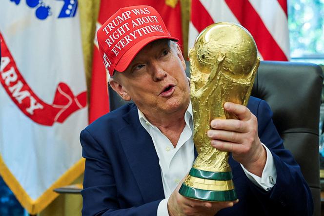 Le président des Etats-Unis, Donald Trump, porte une casquette où il est écrit « Trump avait raison sur tout ! », en tenant le trophée de la Coupe du monde de la FIFA dans le bureau Ovale de la Maison Blanche, à Washington, DC, le 22 août 2025. 