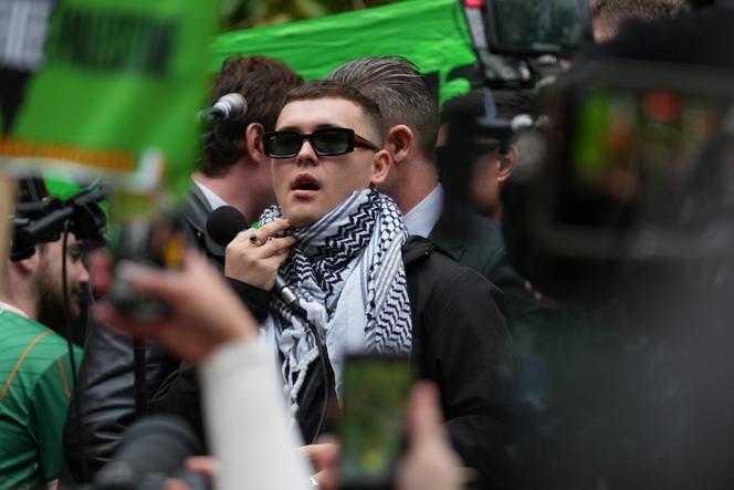 Mo Chara, membre du groupe de musique irlandais Kneecap, célèbre sa victoire après avoir quitté le tribunal de Woolwich Crown Court à Londres, le 26 septembre 2025, après que le magistrat en chef, le juge de district senior Paul Goldspring, eut rejeté une accusation de terrorisme liée à l’affichage d’un drapeau en soutien au Hezbollah lors d’un concert avec le groupe en novembre 2024, en raison d’une erreur technique.