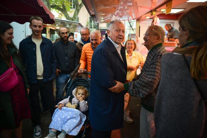L’ancien président de l’Olympique lyonnais, Jean-Michel Aulas (centre), candidat à la mairie de Lyon, sur un marché de la ville, le 23 septembre 2025.