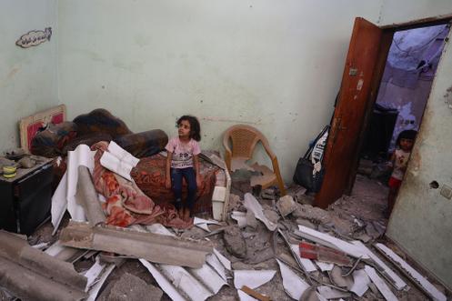 Des enfants palestiniens constatent les dégâts dans une chambre d’une maison touchée par les bombardements israéliens dans le camp de réfugiés de Nousseirat, au centre de la bande de Gaza, le 27 septembre 2025.