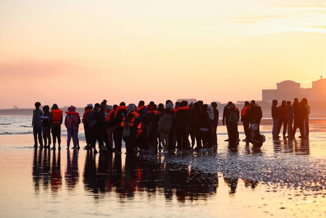 Migrants wait to board a small inflatable boat heading to the United Kingdom, in Calais on September 27, 2025. 