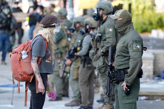 Une manifestante face à des membres de la police de l’immigration (ICE) à Portland, le 14 juin 2025.