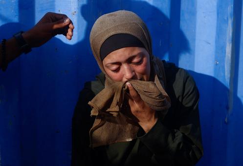Une femme pleure son mari, tué lors de frappes israéliennes nocturnes, à l’hôpital Al-Awda, dans le centre de la bande de Gaza, le 28 septembre 2025.