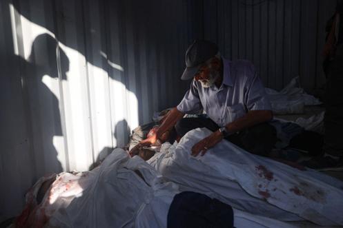 Un Palestinien fait ses adieux à un homme tué dans un bombardement israélien, à l’intérieur d’une structure préfabriquée de l’hôpital Al-Awda, dans le camp de réfugiés de Nousseirat, dans le centre de la bande de Gaza, le 28 septembre 2025.
