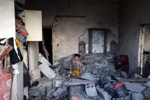 Un enfant palestinien dans les décombres d’une maison fortement endommagée par une frappe israélienne, dans le camp de réfugiés de Nousseirat, au centre de la bande de Gaza, le 28 septembre 2025.