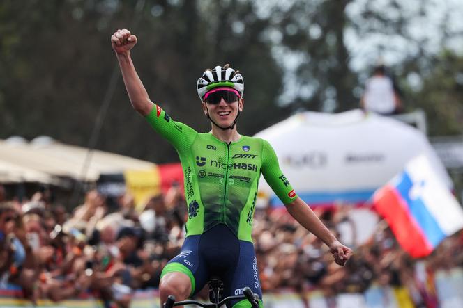 Slovenian rider Tadej Pogacar celebrates as he crosses the finish line to win the men's Elite road race cycling event during the 2025 World Championships, in Kigali, Rwanda, on September 28, 2025.