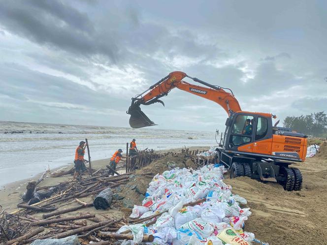 Des ouvriers renforcent la digue routière avant l’arrivée du typhon Bualoi, à Ha Tinh, au Vietnam, le 28 septembre 2025.