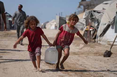 Des Palestiniennes rapportent de l’eau d’un point de distribution installé dans le camp de déplacés de Khan Younès, dans la bande de Gaza, le 29 septembre 2025.