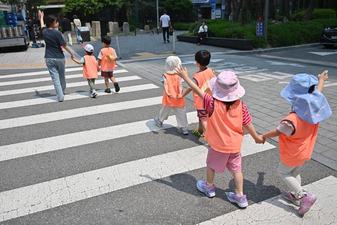 Des enfants traversent une rue à Séoul (Corée du Sud), en mai 2025. 