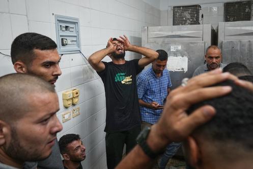 Des proches pleurent les membres de leur famille tués lors d’une frappe israélienne contre un atelier de menuiserie et un café, à l’hôpital Al-Aqsa de Deir Al-Balah, dans le centre de la bande de Gaza, mardi 30 septembre 2025.