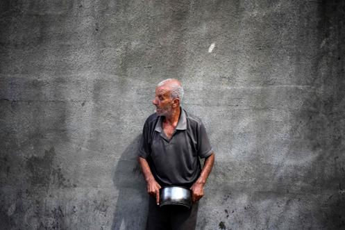 Un réfugié palestinien attend lors d’une distribution alimentaire à Nousseirat, dans le sud de la bande de Gaza, le 30 septembre 2025.