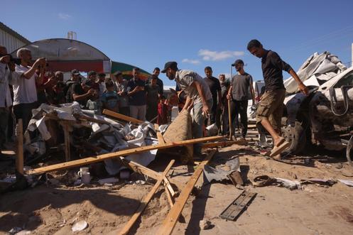 Des personnes inspectent les dégâts causés par une frappe israélienne sur une tente à Deir Al-Balah, dans le centre de la bande de Gaza, le 1ᵉʳ octobre 2025.